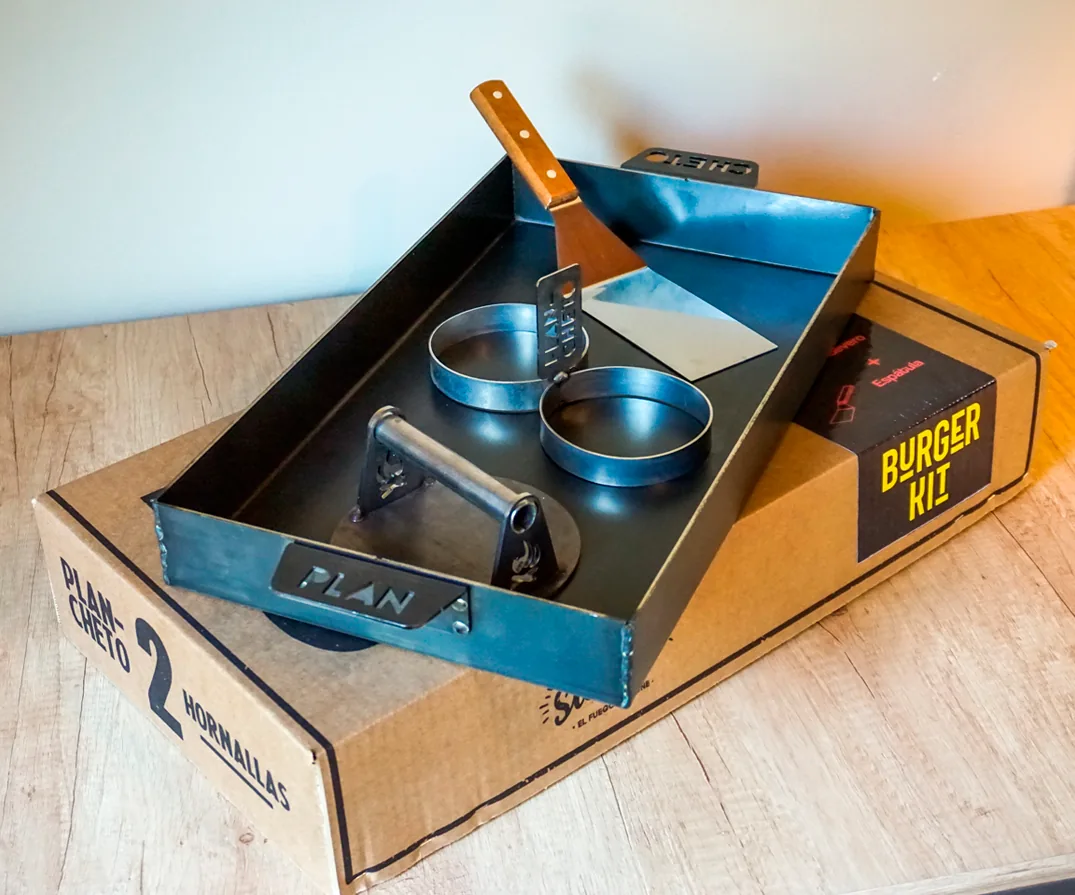 Plancha Plan Cheto con smasher, huevero y espátula sobre su caja